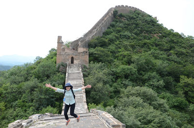 High angle view of woman jumping on great wall of china