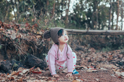 Cute girl looking away while lying on land