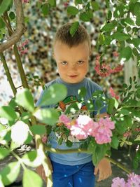 The boy is angry standing in the roses