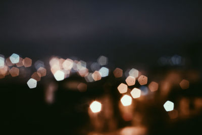 Defocused lights against sky at night