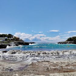 Scenic view of beach against blue sky