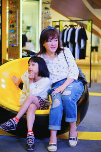 Mother and daughter sitting outdoors