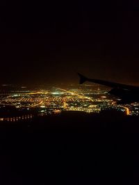 Illuminated cityscape against sky at night