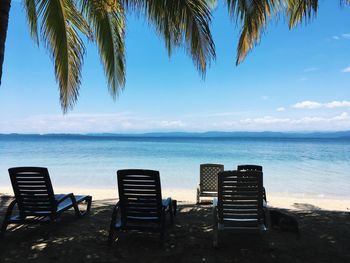 Chairs on beach against sky