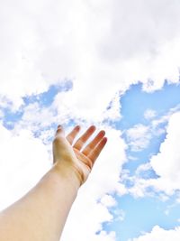 Low angle view of hand against sky