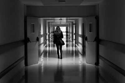 Rear view of man walking in corridor
