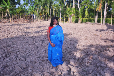 Portrait of woman standing against trees