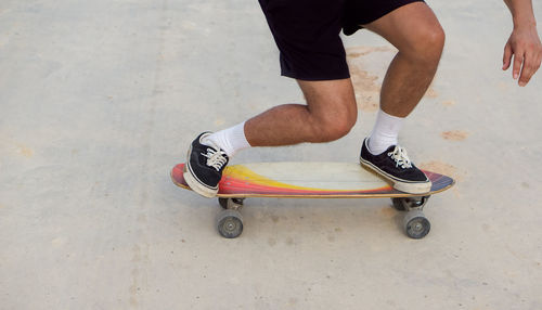 Low section of man skateboarding on street