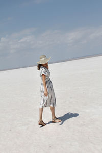 Full length of woman standing on beach against sky