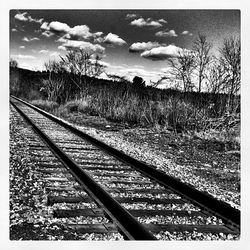 Railroad track against cloudy sky