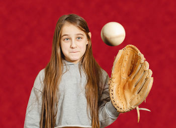 Child with baseball glove and ball. girl with long hair catches ball with baseball glove. 