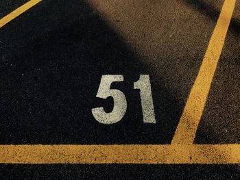 High angle view of arrow sign 51 on road parking