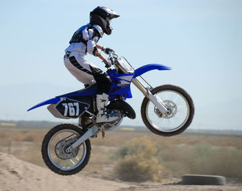 Full length of man riding motorcycle on sand