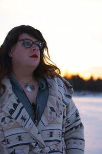 Transgender male looking away during sunset