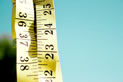 Close-up of tape measure on blue background