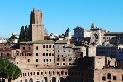 Buildings in city against clear blue sky