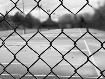 Full frame shot of chainlink fence against tennis court 