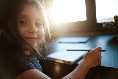 Portrait of woman reading book at home