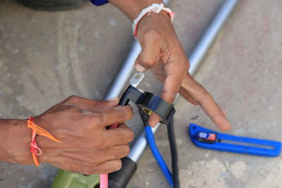 Low section of electrician sticking adhesive tape on cable