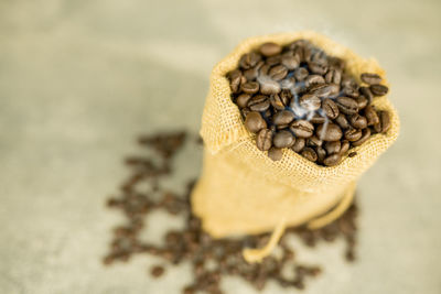 High angle view of roasted coffee beans in sack on table