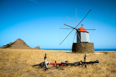 Traditional windmill on field against blue sky during bike trip