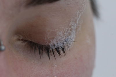 Close-up of soap sud on closed woman eyelash
