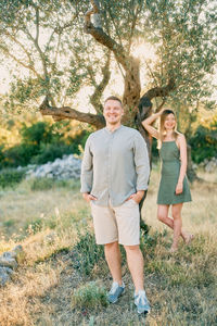 Portrait of smiling friends standing on field