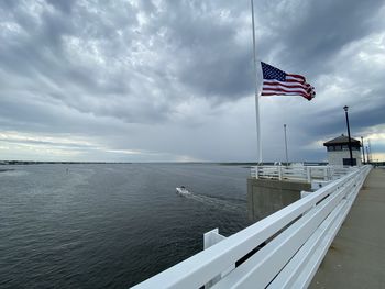 Flag on sea against sky