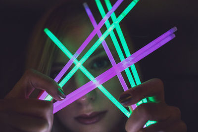 Woman holding colorful equipment at night