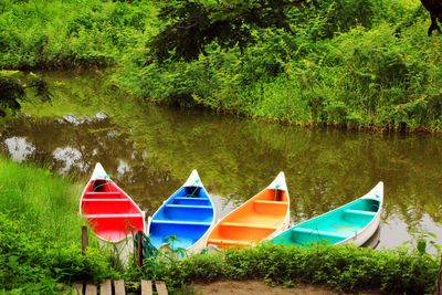 Boats in river with trees in background