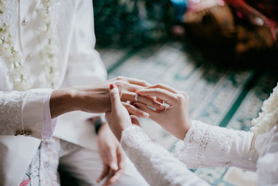 Midsection of couple holding hands