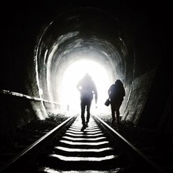 Rear view of woman walking in tunnel