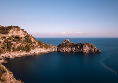 Scenic view of rocks in sea against sky