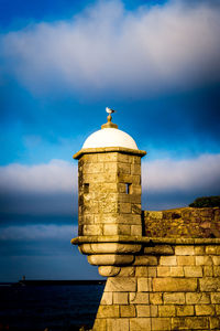 Lighthouse against cloudy sky