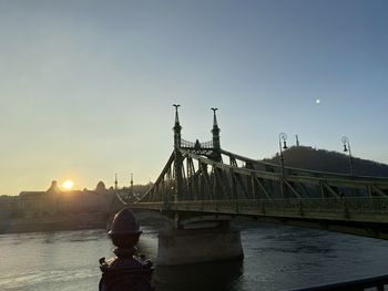 View of bridge over river during sunset