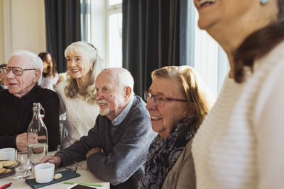Happy elderly men and women looking away at retirement home