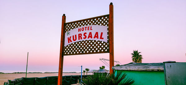 Information sign on beach against clear sky