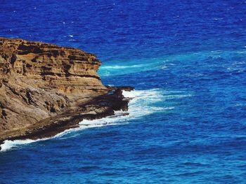 Scenic view of sea by cliff