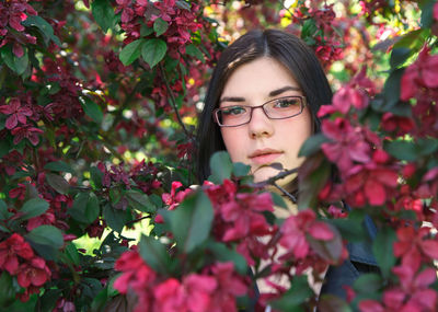 Portrait of young woman with red flowers