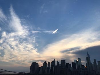 Buildings in city against cloudy sky