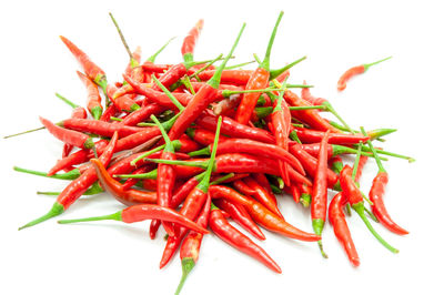 Close-up of red chili peppers over white background