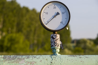 Old pressure gauge on an old pipe. front view, outdoors horizontal shot.