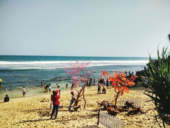 People on beach against clear sky