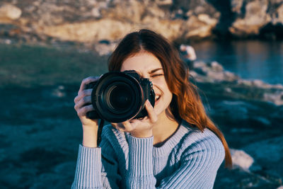 Portrait of young woman photographing