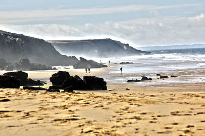 Scenic view of beach by rock formations