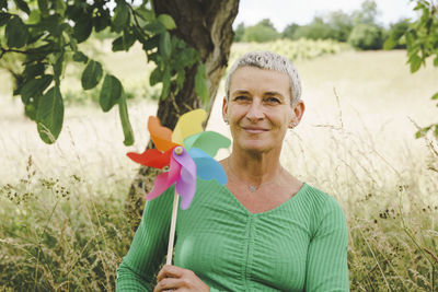 Portrait of young woman standing against plants