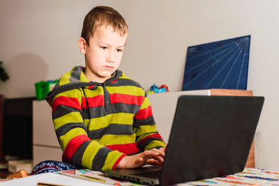 Boy sitting on table at home