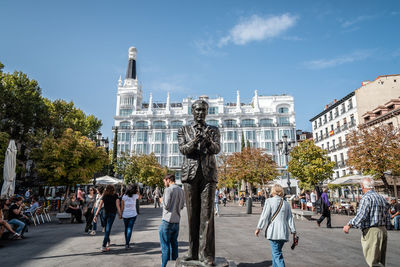 People at town square against sky in city