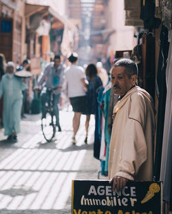 Rear view of people walking on street in city