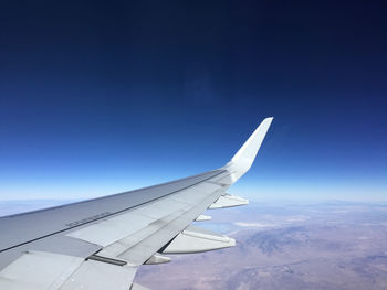 Close-up of a cropped airplane against clear blue sky